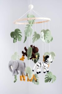 jungle animal baby mobile with safari theme hanging above crib, nursery decor with lions giraffes and elephants, soft neutral baby room accessory