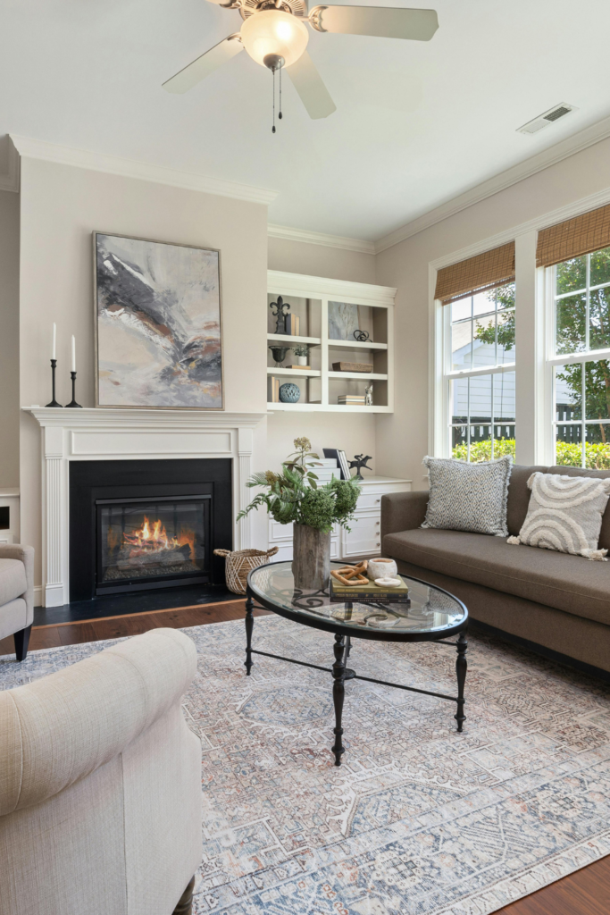 Minimalist and organized living room with neutral tones, sofa, coffee table, fireplace, and natural light for a calm home environment.