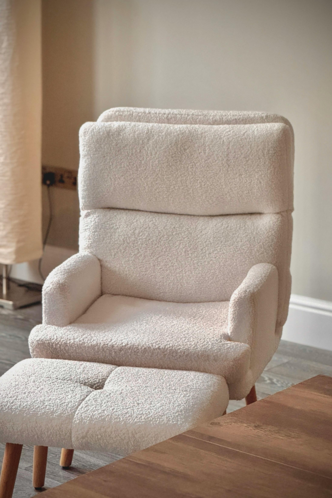 Cream oversized accent chair with matching ottoman in a neutral living room