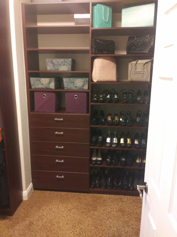 Beautiful custom closet featuring organized shelves, storage bins, handbags, shoes, and built-in drawers.